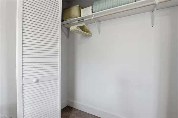 a bedroom with two beds and a dresser next to a window