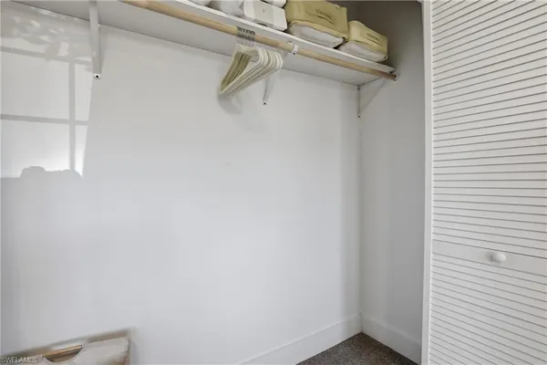 a walk in closet with wooden floor