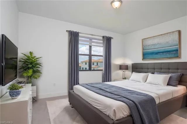 a bedroom with a bed and a potted plant