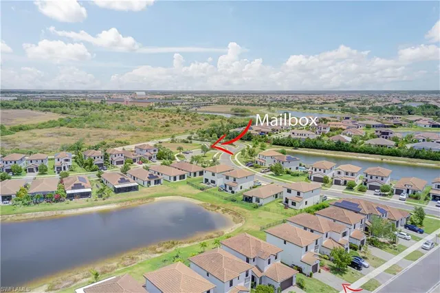 an aerial view of a city with lots of residential buildings ocean and mountain view in back