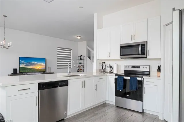 a kitchen with stainless steel appliances a stove a sink and a microwave