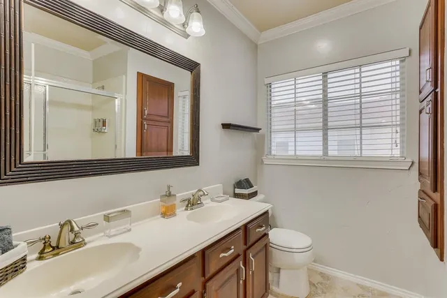 a bathroom with a granite countertop sink vanity mirror and toilet
