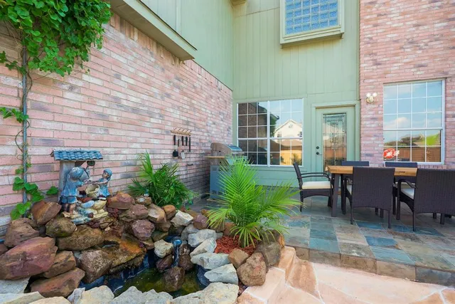 a view of a patio with plants and chairs