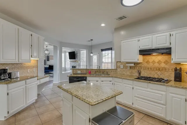 a kitchen with stainless steel appliances granite countertop a sink stove and cabinets