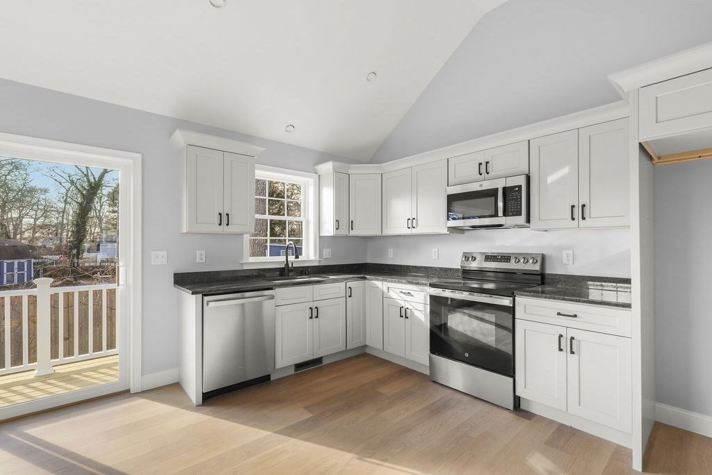 81 Maple Springs Road Wareham, MA 02571 - Photo 3 of 17 a kitchen with granite countertop white cabinets a sink a window and stainless steel appliances