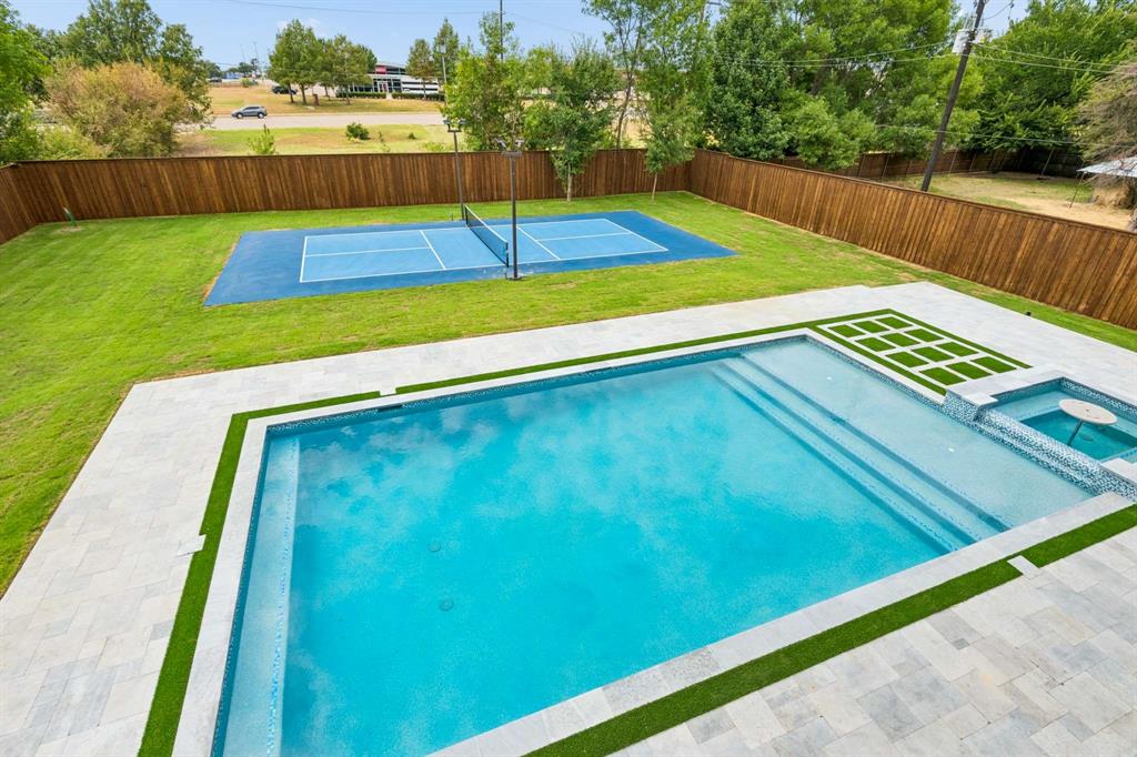 6606 Curtis Road Colleyville, TX 76034 - Photo 31 of 39 Expansive backyard featuring a rectangular swimming pool with integrated spa, a dedicated sports court, and a privacy fence