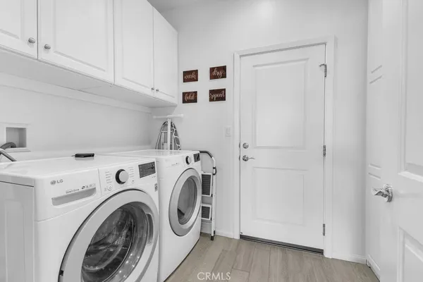 a view of washer and dryer with kitchen in the background