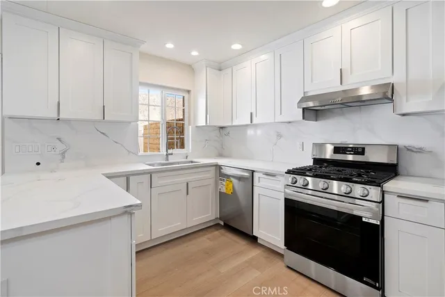 a kitchen with a stove sink and cabinets