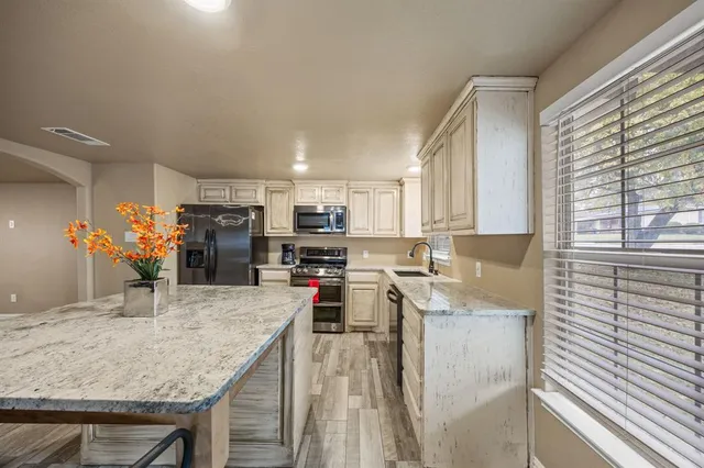 a kitchen with stainless steel appliances granite countertop a sink refrigerator and microwave