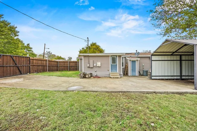 a view of a yard in front of a house with large tree