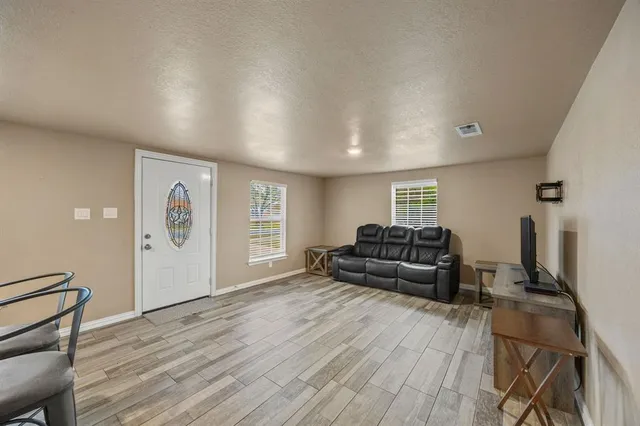 a living room with furniture and wooden floor
