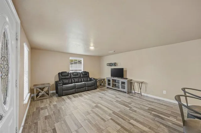 a living room with furniture and a wooden floor