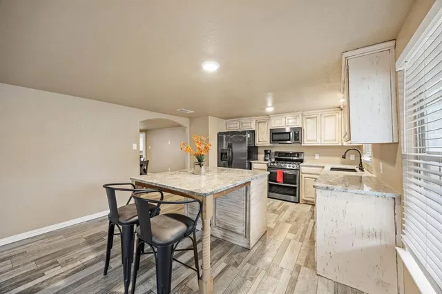 a kitchen with stainless steel appliances a table and chairs in it