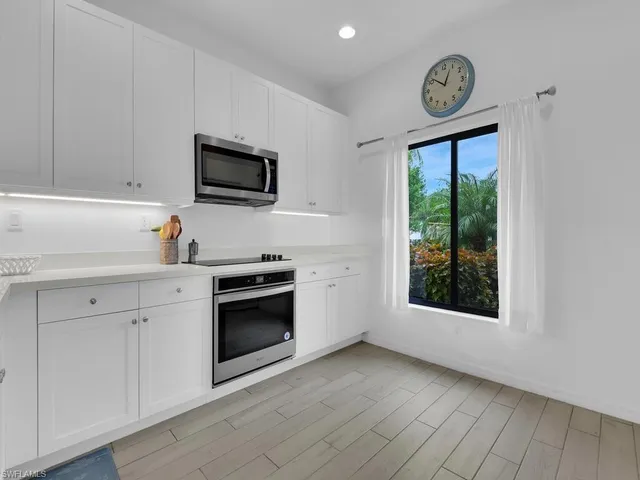 a kitchen with stainless steel appliances a stove microwave and sink