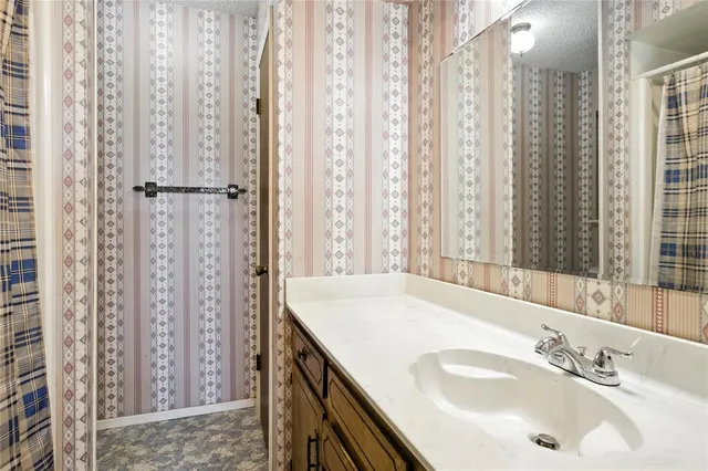a bathroom with shower sink and a mirror