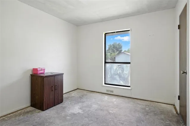 an empty room with windows and cabinet