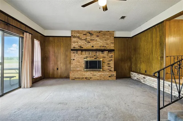 an empty room with fireplace cabinet and windows