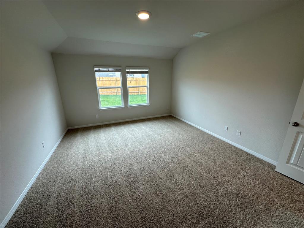 563 Evergreen Sumac Loop Kyle, TX 78640 - Photo 13 of 18 A spacious room with soft carpet and natural light pouring in through the windows.