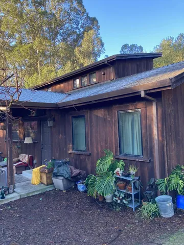 a view of a chair and table in backyard of the house