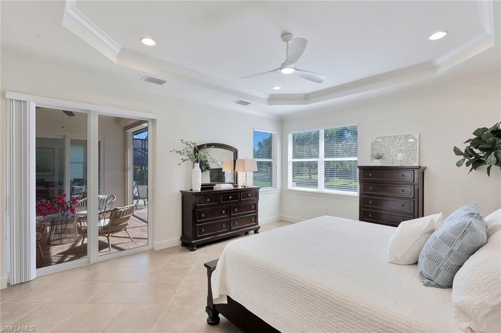 9058 Limestone Lane Naples, FL 34120 - Photo 15 of 48 a bedroom with a large bed and windows