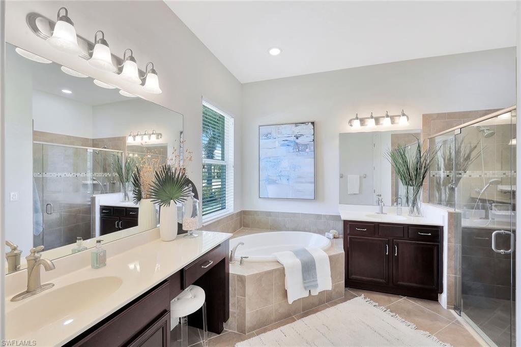 9058 Limestone Lane Naples, FL 34120 - Photo 16 of 48 a spacious bathroom with a granite countertop sink a toilet a large mirror and shower