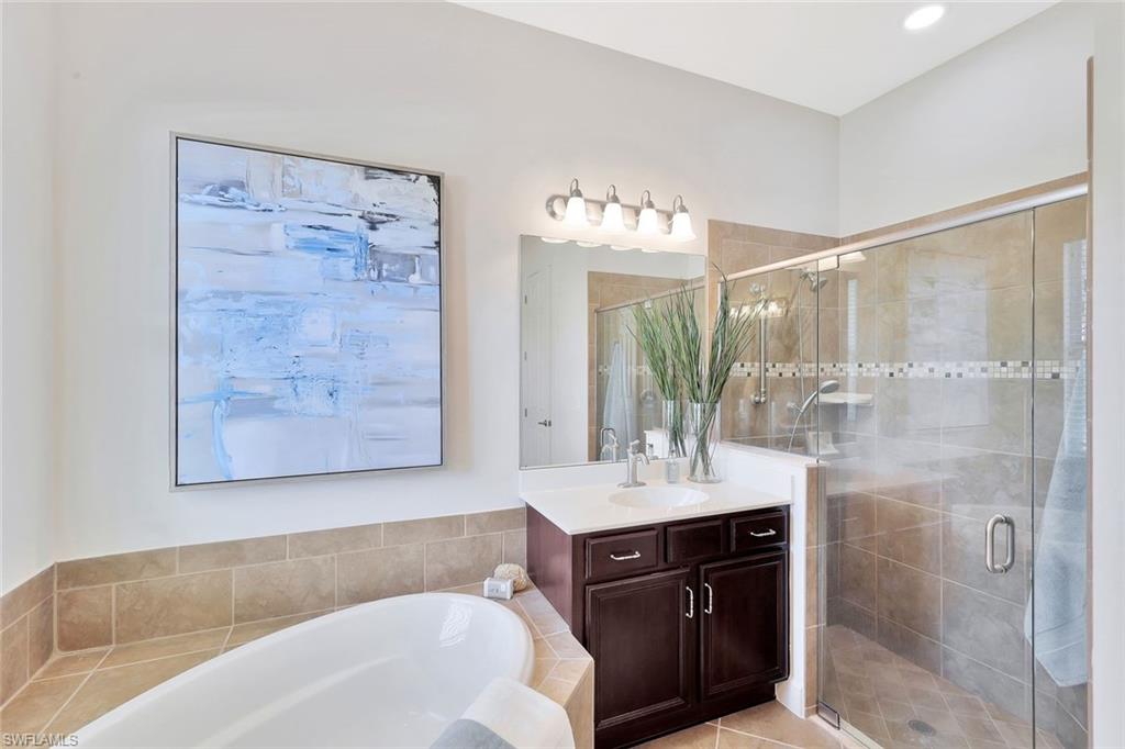 9058 Limestone Lane Naples, FL 34120 - Photo 17 of 48 a bathroom with a bathtub shower sink and mirror