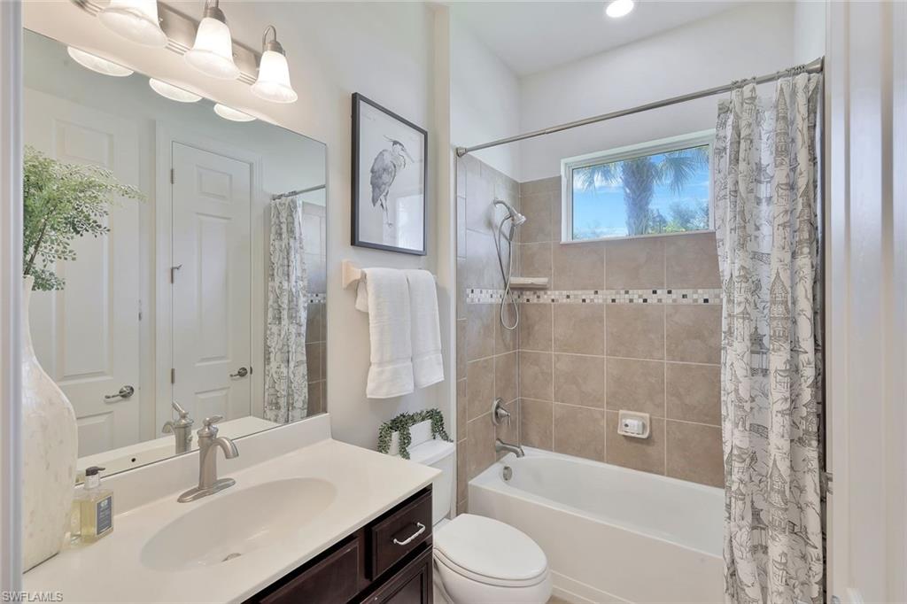 9058 Limestone Lane Naples, FL 34120 - Photo 19 of 48 a bathroom with a bathtub shower sink vanity and toilet