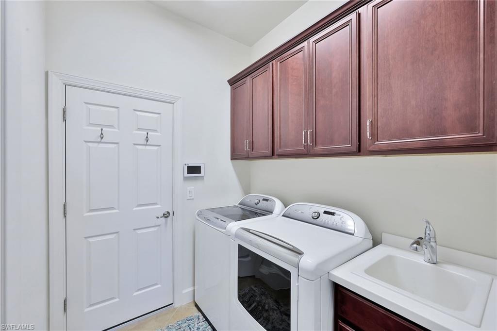 9058 Limestone Lane Naples, FL 34120 - Photo 20 of 48 a utility room with sink dryer and washer