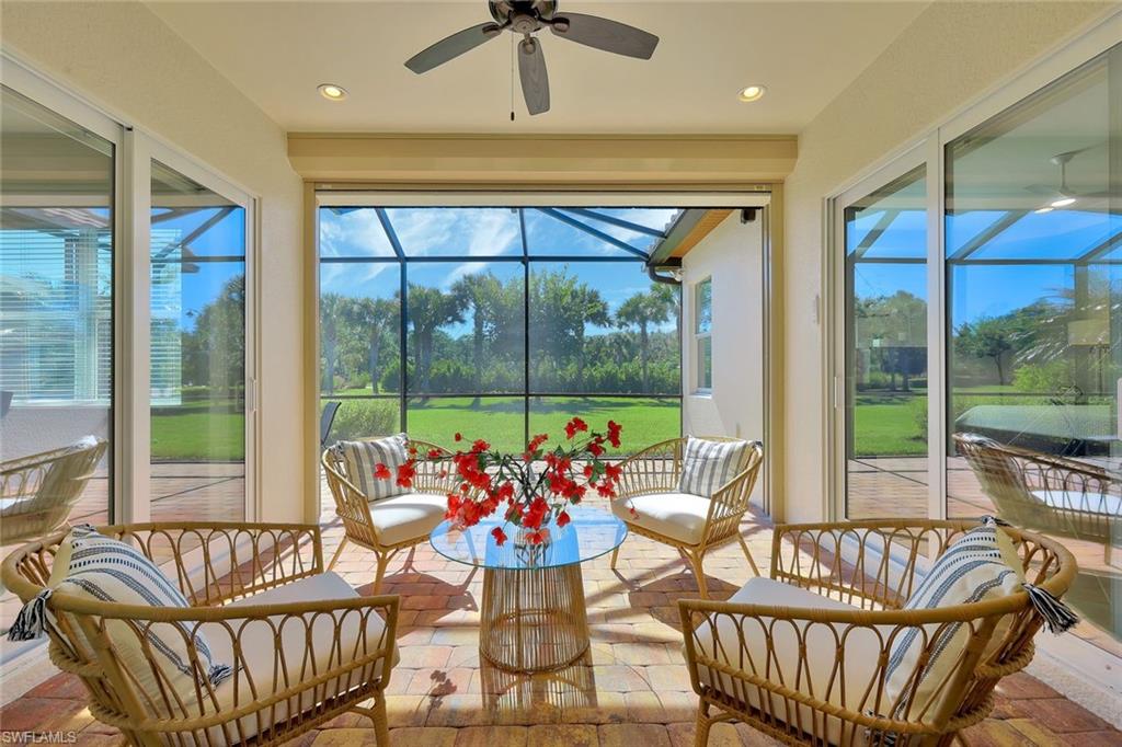 9058 Limestone Lane Naples, FL 34120 - Photo 21 of 48 a living room with furniture and floor to ceiling windows