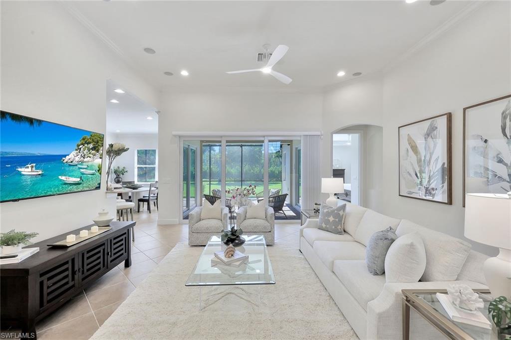 9058 Limestone Lane Naples, FL 34120 - Photo 3 of 48 a living room with furniture and a flat screen tv