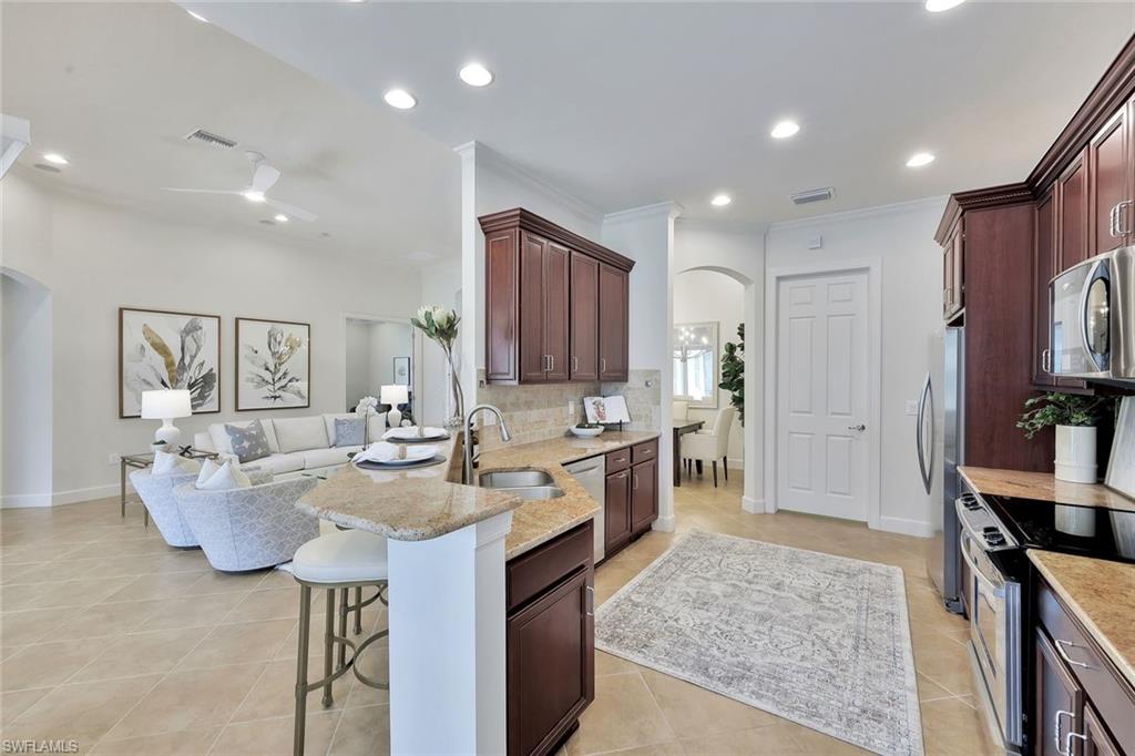 9058 Limestone Lane Naples, FL 34120 - Photo 9 of 48 a large kitchen with a large counter top appliances and cabinets