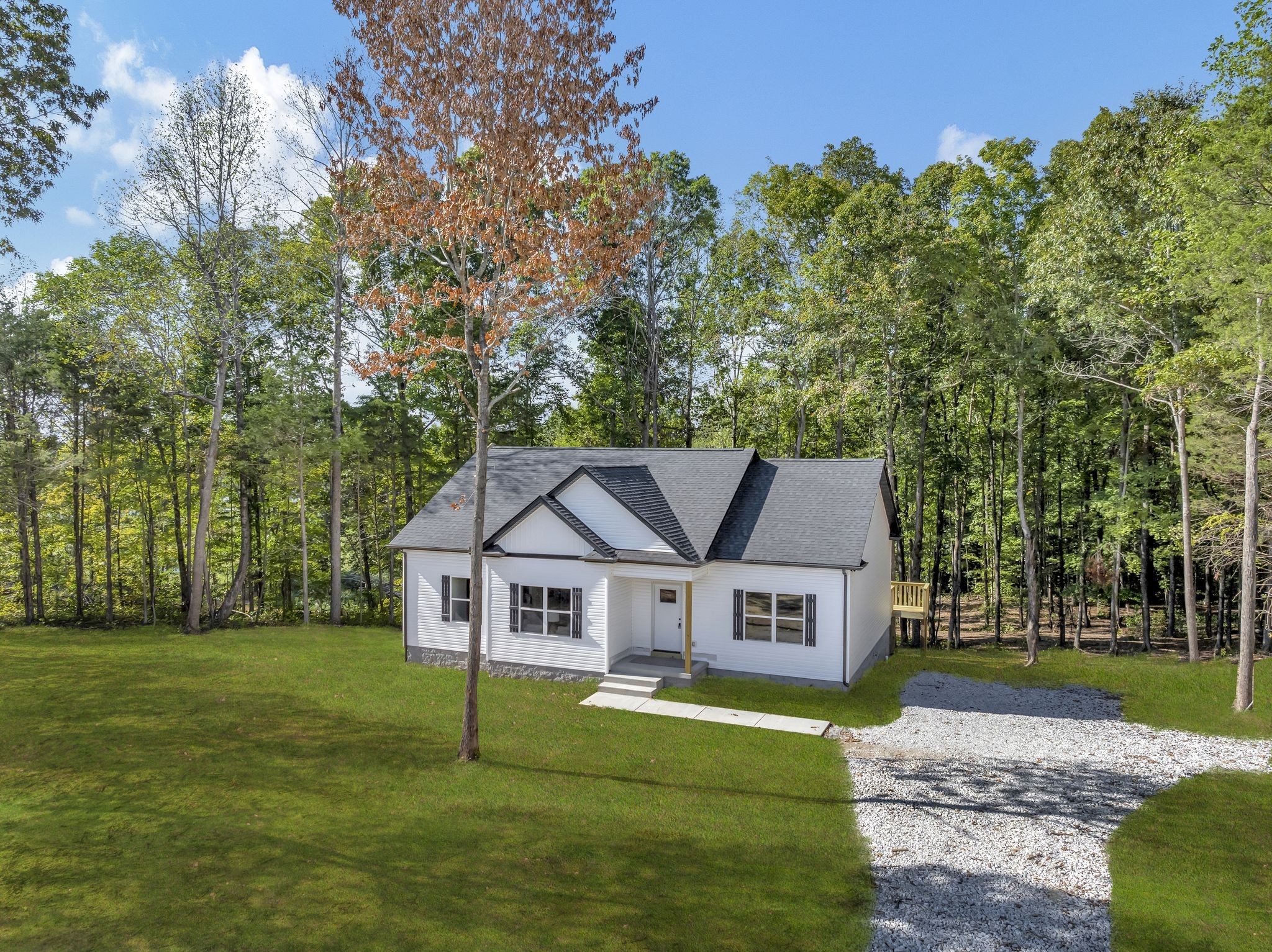 1514 East Piney Road Dickson, TN 37055 - Photo 28 of 29 a white house with a big yard and large trees