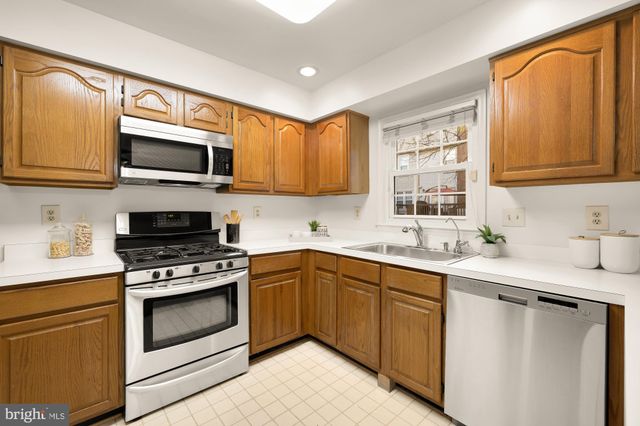 a kitchen with stainless steel appliances granite countertop a sink stove microwave and cabinets