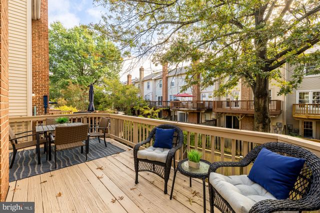 a balcony with wooden floor table and chairs