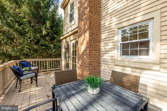 a view of a balcony with wooden bench and potted plants
