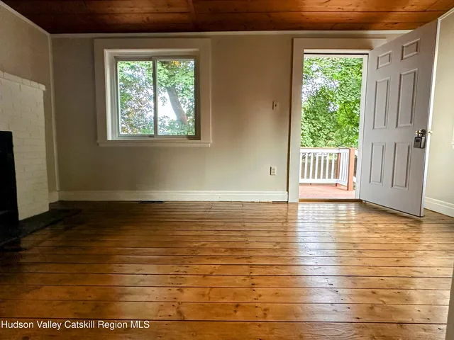 a view of a room with wooden floor and a window