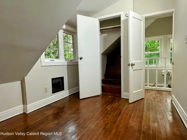 a view of a hallway with wooden floor and staircase