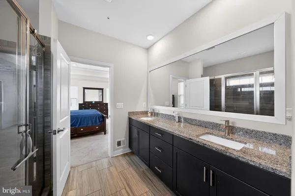 a en suite bathroom with a tub double sink and mirror