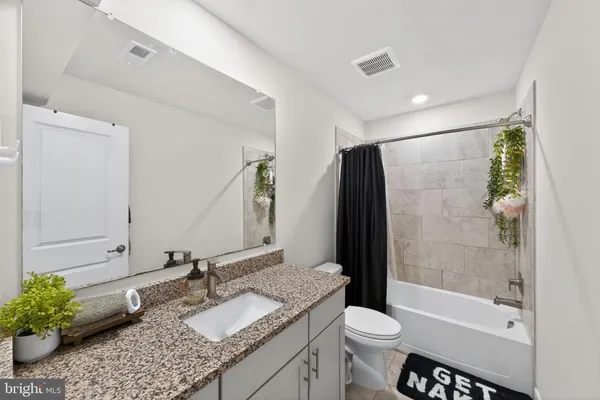 a bathroom with a granite countertop sink toilet and shower