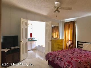 7268 Gas Line Road Keystone Heights, FL 32656 - Photo 9 of 12 a bedroom with a bed and a flat screen tv