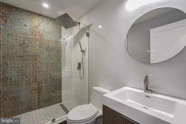 a view of an empty room with wooden floor and windows