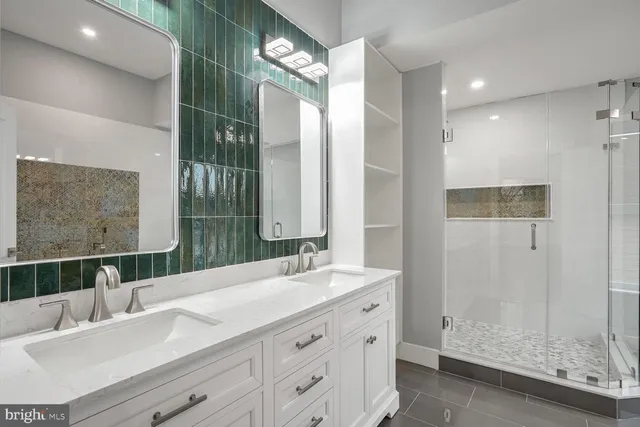 a bathroom with a double vanity sink mirror and shower