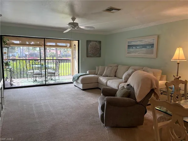 a living room with furniture and a floor to ceiling window