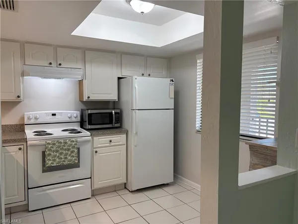a kitchen with a stove top oven and refrigerator