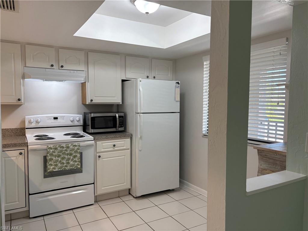 5841 Rattlesnake Hammock Road, Unit I203 Naples, FL 34113 - Photo 9 of 20 a kitchen with a stove top oven and refrigerator