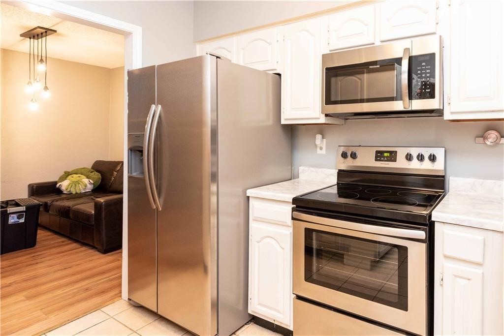 1910 Robbins Place, Unit 210 Austin, TX 78705 - Photo 7 of 13 a kitchen with stainless steel appliances granite countertop a refrigerator stove and microwave