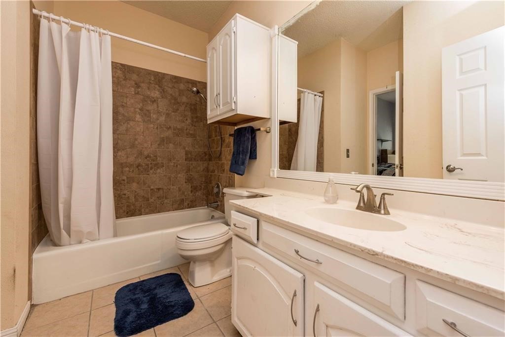 1910 Robbins Place, Unit 210 Austin, TX 78705 - Photo 9 of 13 a bathroom with a sink a toilet a mirror and shower