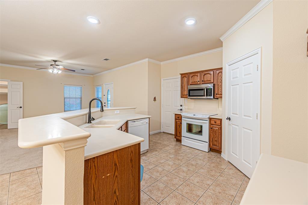 105 Sunglow Loop Red Oak, TX 75154 - Photo 17 of 40 a kitchen with stainless steel appliances a stove a sink and a refrigerator