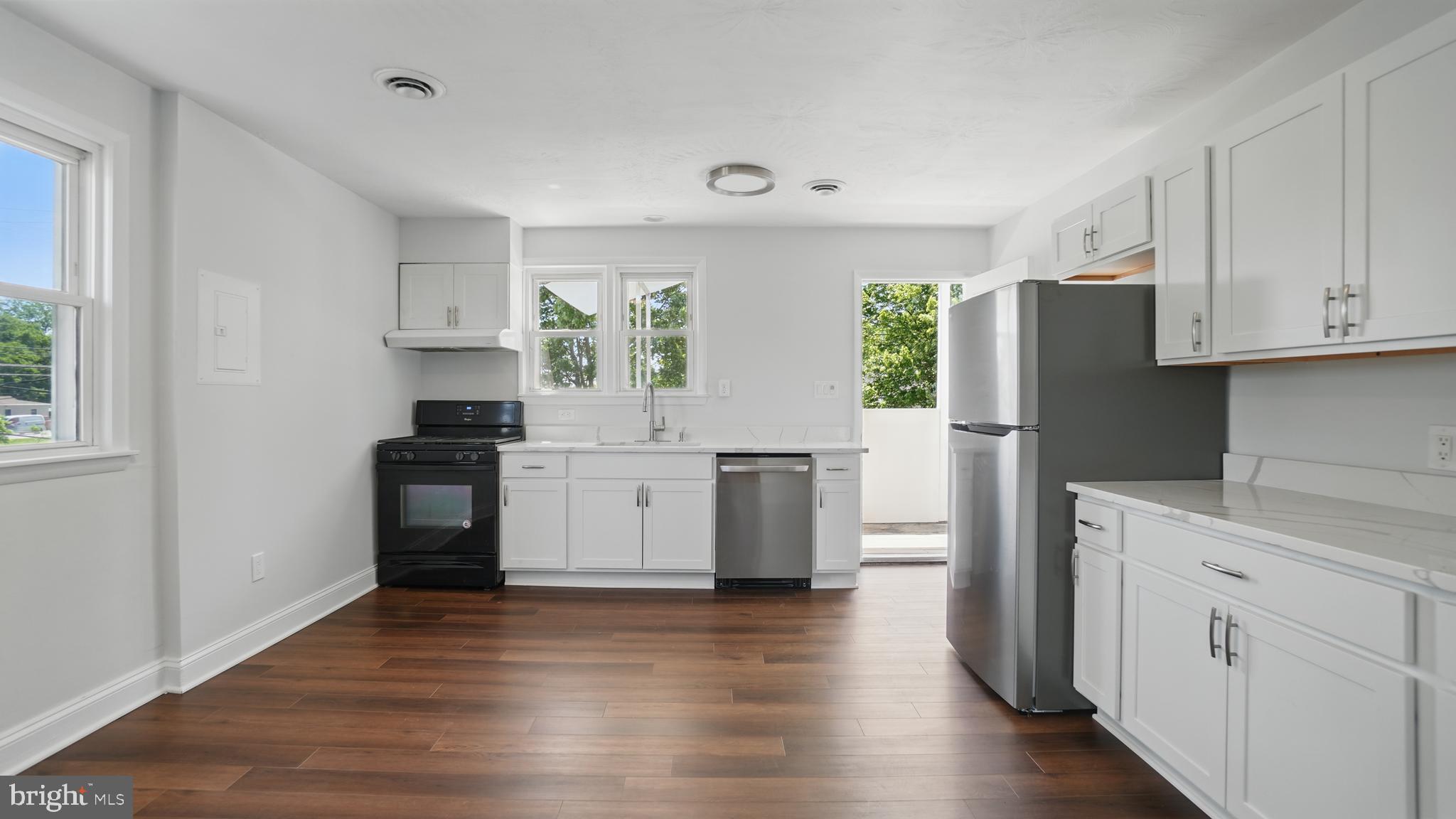 8014 Ritchie Highway Pasadena, MD 21122 - Photo 21 of 38 a kitchen with white cabinets and wooden floor