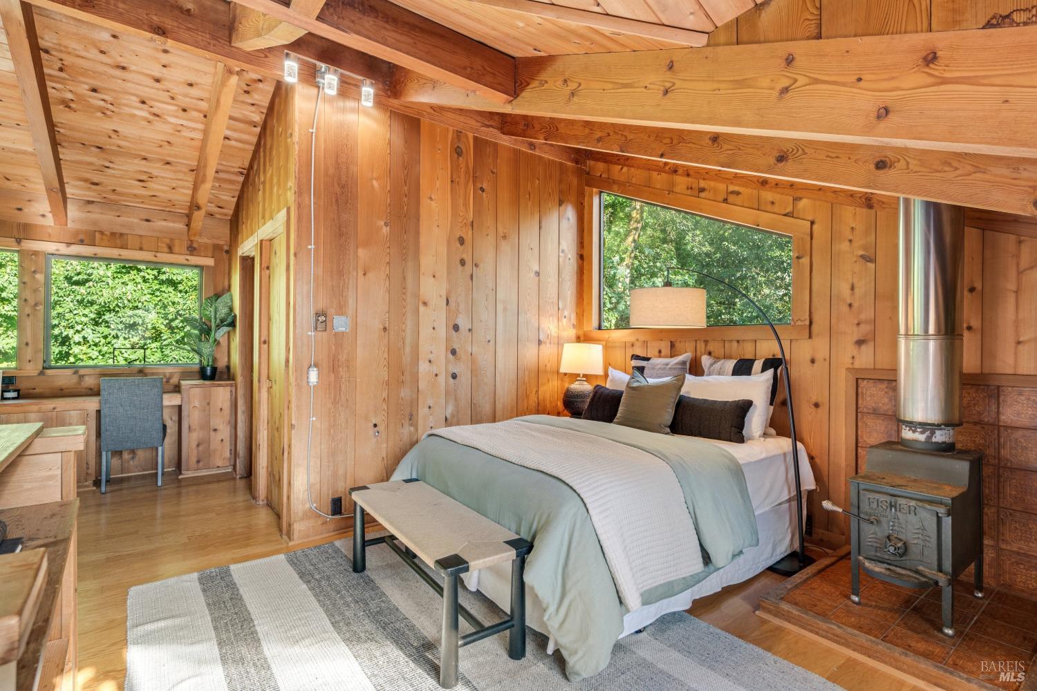 805 Wagnon Road Sebastopol, CA 95472 - Photo 24 of 56 a bedroom with a bed a table and large mirror with wooden floor